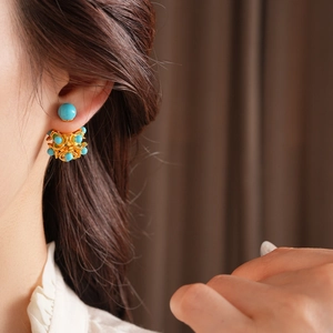 Gros plan de boucles d'oreilles vintage fleurs en résine avec perles turquoises