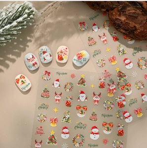 Detailed view of festive Christmas nail art stickers featuring Santa, elk, and trees