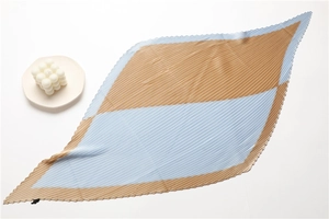 Detail of pleated two-tone scarf in brown and light blue with geometric pattern