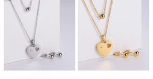 Detailansicht der doppellagigen Herzanhänger-Halskette und Kugelohrringe in Silber und Gold