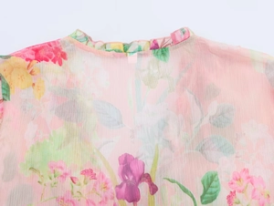 Detail of ruffled collar and floral print on pink semi-transparent poplin shirt