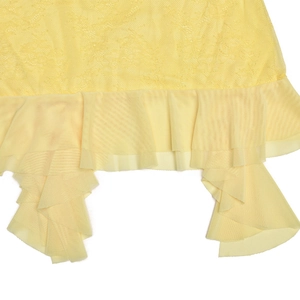 Gros plan détaillé du tissu en dentelle jaune et de l'ourlet à volants en tulle