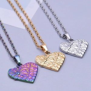 Détail des pendentifs cœur avec texture florale en finitions dorée, argentée et irisée