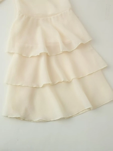 Dettaglio delle balze a strati su una gonna in chiffon beige con trama delicata