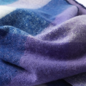 Close-up of soft cashmere-like texture with blue and purple plaid pattern on scarf