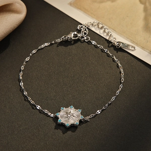 Silver octagonal star bracelet with blue beads and zircon on dark textured background