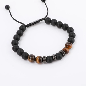 Detail of beaded lion crown bracelet with matte black beads and tiger eye stones