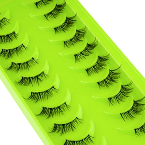 Macro shot of 10 pairs of dense crisscross false eyelashes on a green display tray