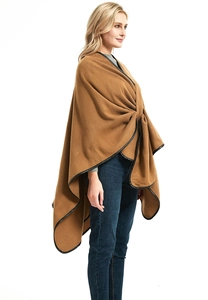 Detail of camel shawl featuring black leather trim and elegant draped side profile
