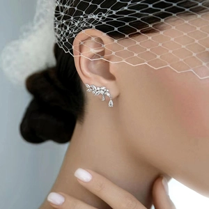 Macro shot of silver leaf ear crawler earrings with cubic zirconia on bridal model