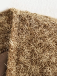 Detailed macro view of high-quality brown plush knit fabric with soft long fiber texture