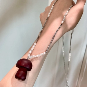 Détail du collier pendentif champignon avec perles de cristal et charme en bois