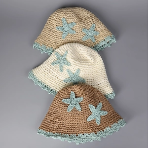 Detailed knit texture of handmade straw bucket hats with starfish appliques and crochet lace