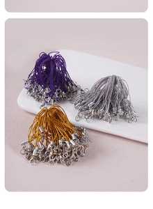 Dettaglio di cordini colorati fai-da-te con chiusure a moschettone su piatto ceramico