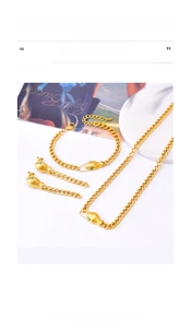 Macro shot of gold titanium steel snake jewelry set with green zircon and cuban chains