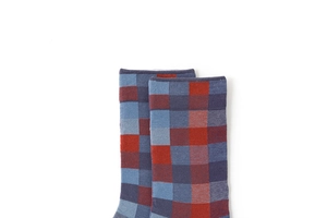 Macro shot showing the elastic cuff texture of red and blue checkered knit crew socks