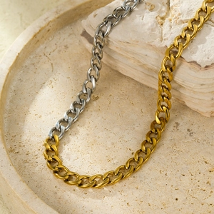 Two-tone gold and silver stainless steel cuban link chain necklace on stone base
