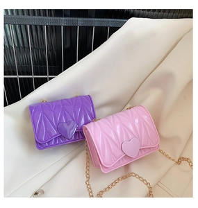 Detail of pink and purple silicone heart bags with gold chain and quilted texture