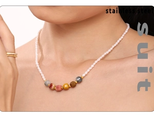 Detail of beaded necklace with freshwater pearls and colorful stones on stainless steel