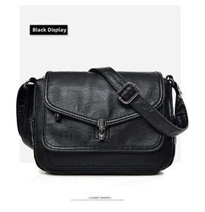 Close-up of vintage black soft leather crossbody bag with metal buckle and textured finish