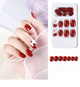 Detail view of 24pcs glossy red press-on nails featuring white 3D bowknot accents
