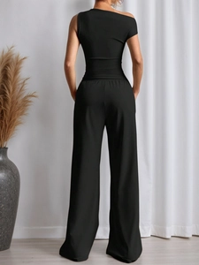 Women's black two-piece set featuring a one-shoulder crop top and high-waisted wide-leg pants