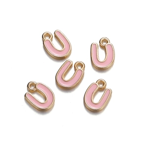 Close-up of five pink enamel U-shaped charms with golden metal edges and hanging loops