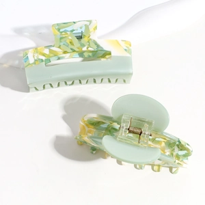 Detail view of large marble green and solid mint green acetate hair claw clips