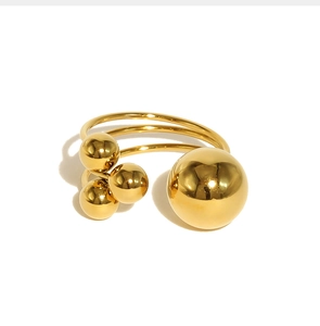 Close-up of golden stainless steel ring with polished triple bands and four spheres