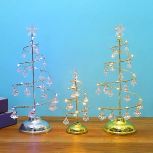 Close-up of golden and silver metal Christmas trees with hanging crystal pendants