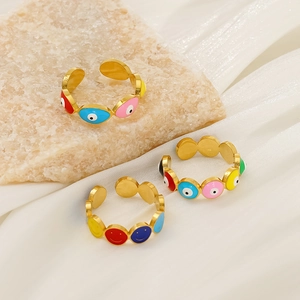 Close-up of gold adjustable evil eye and smiley rings with colorful enamel on stone