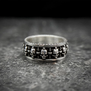 Macro shot of detailed vintage silver skull relief patterns on a wide gothic ring band
