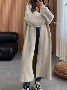 Vue détaillée d'un gilet long en maille beige avec une silhouette élégante et moderne