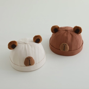 Detailed view of children's cotton bear hats in beige and brown with plush ears