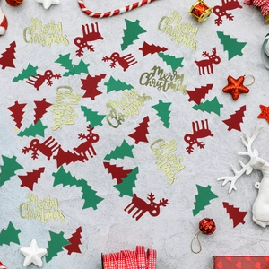Flat lay of red reindeer and green tree confetti with gold Merry Christmas sequins