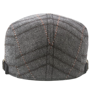 Detail of grey plaid flat cap showing tweed texture and adjustable side metal buckle