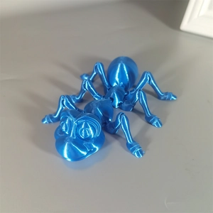 Macro shot of 3D printed blue ant toy with silk PLA metallic texture on grey background