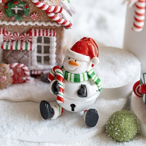 Christmas snowman bell ornament with red hat and scarf on snowy background
