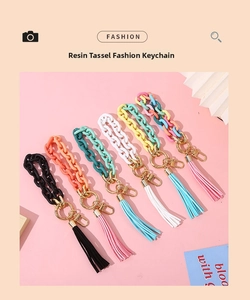Detail of colorful resin chain keychains with gold metal clasps and long tassels