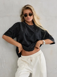 Detail of vintage washed black cotton T-shirt showing distressed texture and dropped shoulder
