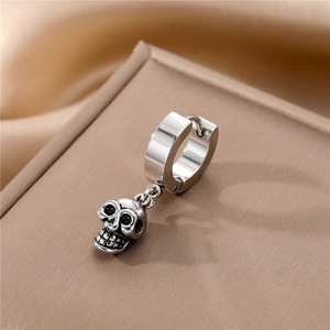 Detail of silver stainless steel hoop earring featuring a gothic skull charm pendant