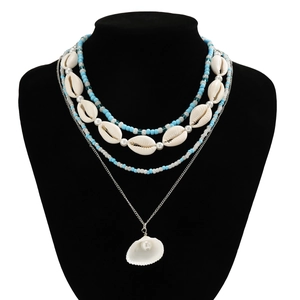 Detail of bohemian layered necklace with white shells, blue beads and a pearl shell charm