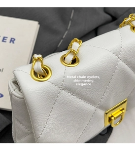 Detail of white quilted leather bag with gold chain strap and metallic grommets