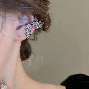 Close-up of silver liquid metal ear cuff with zircon stones on a female model
