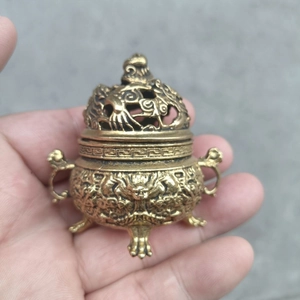 Detail of vintage bronze incense burner with dragon carvings and hollowed lid
