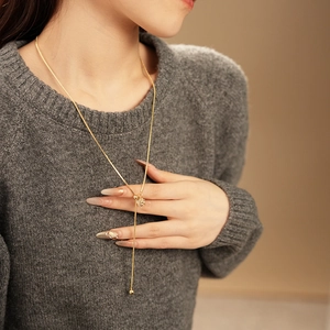 Detail of gold-plated tassel Y-necklace with zircon crystals on model neck