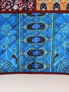 Close-up of diamond quilted floral patchwork fabric with ethnic paisley and flower motifs