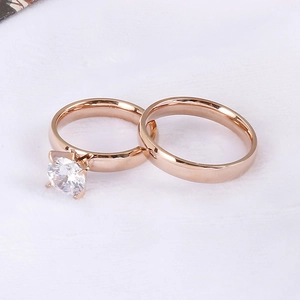 Nahaufnahme von Eheringen aus Roségold mit einem Solitär-Diamanten und schlichtem Band