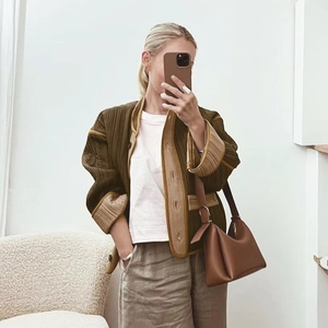 Women's olive green quilted jacket with contrast trim and loose fit design