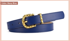 Detailed macro view of the navy blue leather belt with a golden bamboo buckle